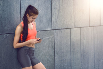 Side view of woman using mobile phone in city