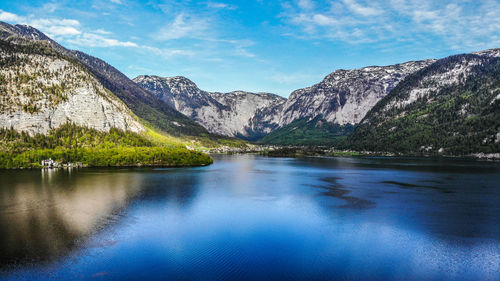 Scenic view of lake by mountains against sky