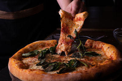 Midsection of man preparing pizza