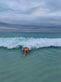 Man surfing in sea against sky
