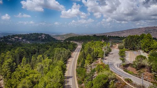 High angle view of road amidst trees against sky