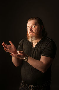 Midsection of man standing against black background