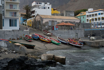 Boats moored in canal by buildings in city