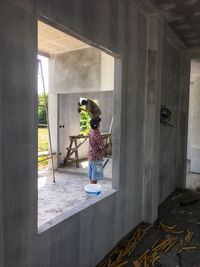 Rear view of woman standing against entrance of building