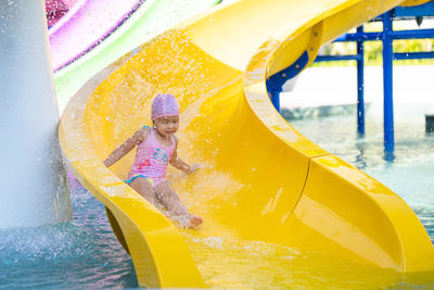 Full length of happy girl in swimming pool at playground