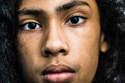 Close-up portrait of boy against black background