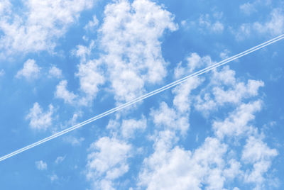 Low angle view of vapor trail against blue sky