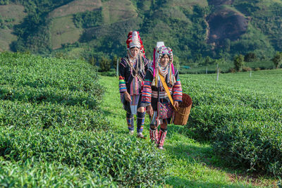 Rear view of people standing in field