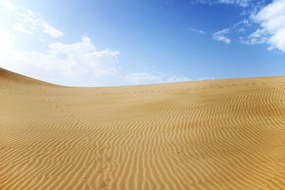 Scenic view of sand dunes against sky