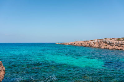 Scenic view of sea against clear blue sky