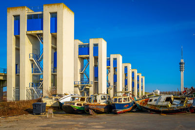 Boats moored at pier against blue sky