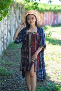 Young woman standing against trees