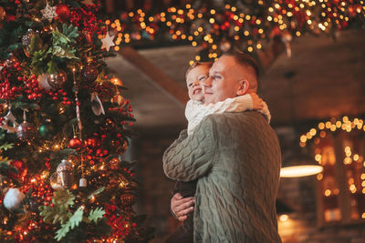 Smile little boy and dad having fun with each other hugs and kisses indoor waiting santa.