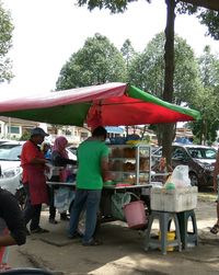 People at market stall against sky