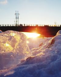 Close-up of snow against sky during sunset