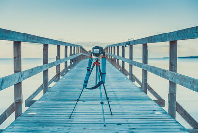 Footbridge over sea against clear sky