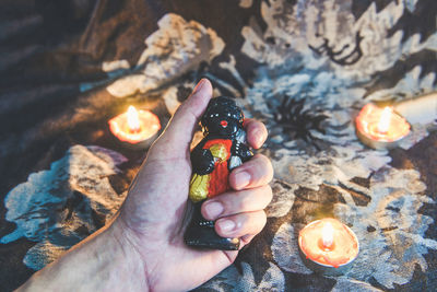 Close-up of hand holding burning candles