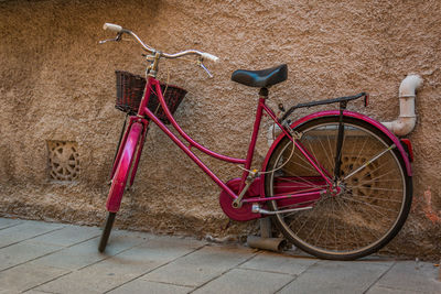 Side view of bicycle parked against wall