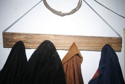 Low angle view of clothes drying on wood against wall