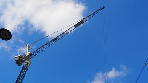 Low angle view of cranes against sky