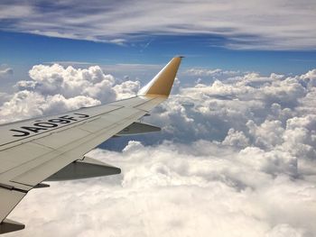 Cropped image of airplane flying over clouds