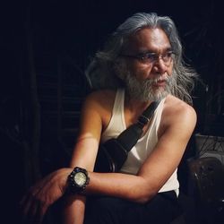 Man wearing heartbeat belt while looking away in darkroom