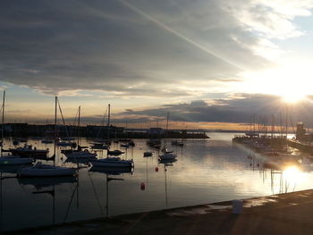 Boats in sea at sunset