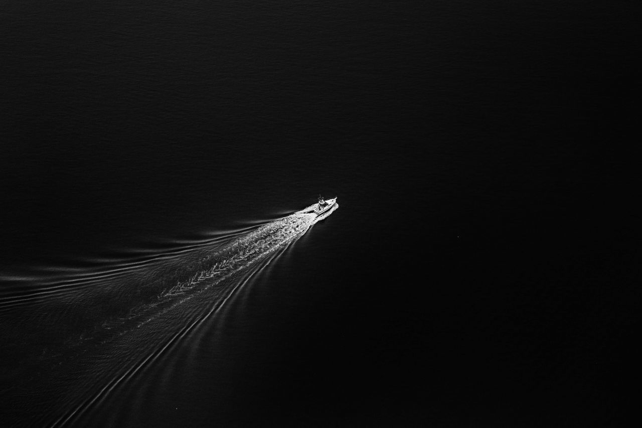 CLOSE-UP OF FEATHER AGAINST SKY OVER BLACK BACKGROUND