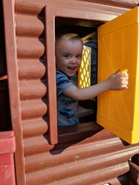 Portrait of cute happy boy seen through window