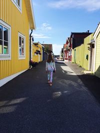 Rear view of woman walking on road