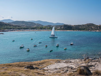 Sailboats in sea against clear sky
