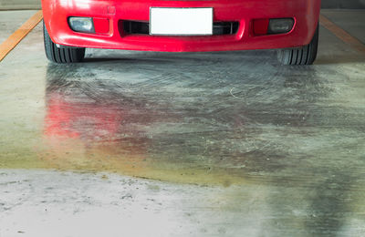 Reflection of red car on wet street