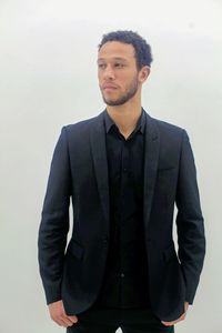 Portrait of young man standing against white background