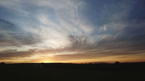 Scenic view of dramatic sky over silhouette landscape