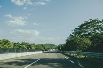 Road amidst trees against sky