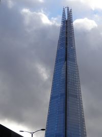 Low angle view of modern building against cloudy sky