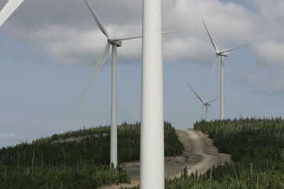 Windmills on field against sky