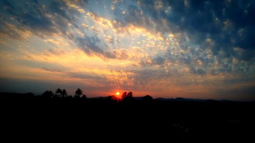 Scenic view of silhouette landscape against orange sky