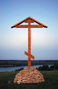 Orthodox cross on rocks against blue sky