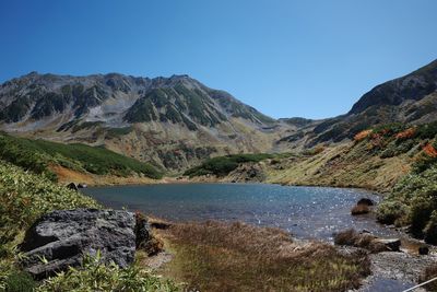 Scenic view of mountains against clear blue sky