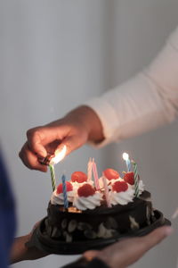 Cropped hand of person holding birthday cake