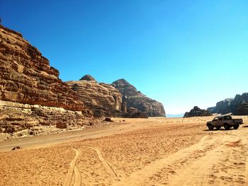 Scenic view of desert against clear blue sky