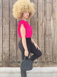 Full length of woman standing against wall