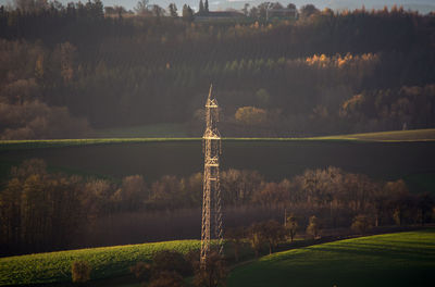 High-voltage line through hilly terrain in the morning sun