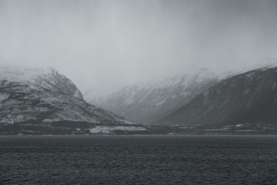 Scenic view of lake by mountains against sky