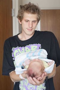 Portrait of young man holding camera at home