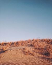 Scenic view of desert against clear blue sky