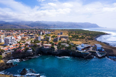 High angle view of buildings by sea against sky