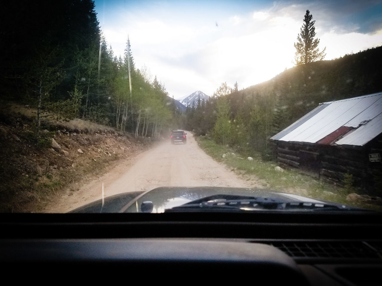 CAR ON ROAD AGAINST SKY SEEN THROUGH WINDSHIELD