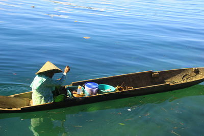 High angle view of man sitting on boat in lake